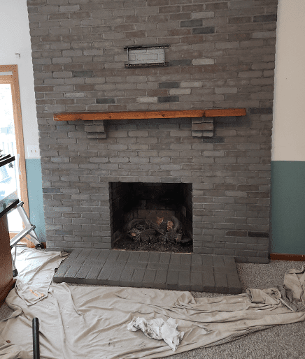 A fireplace in the process of being painted.