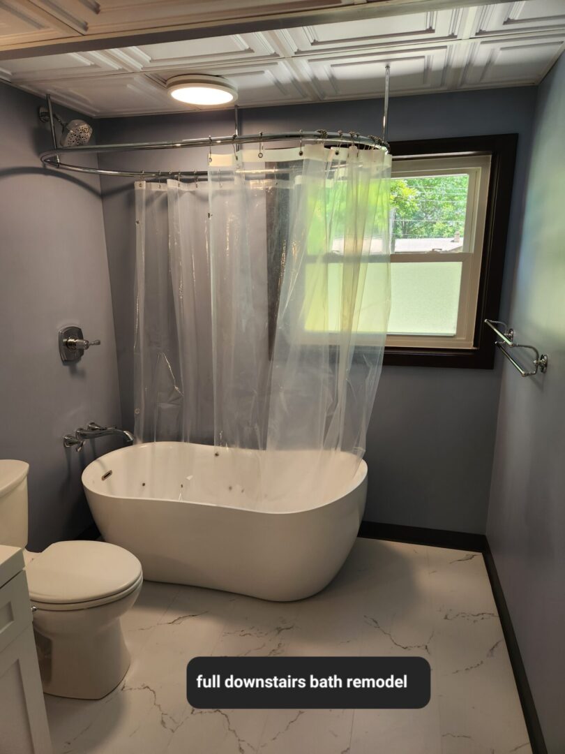 A bathroom with a tub, toilet and shower.