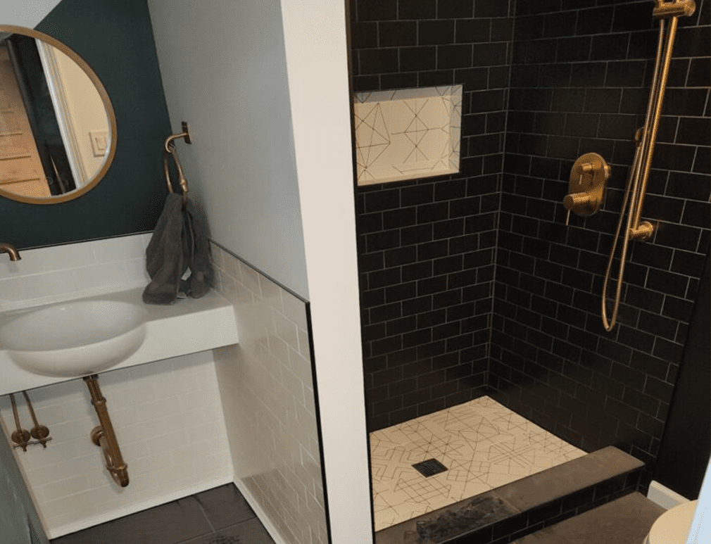 A bathroom with black tile and white walls.